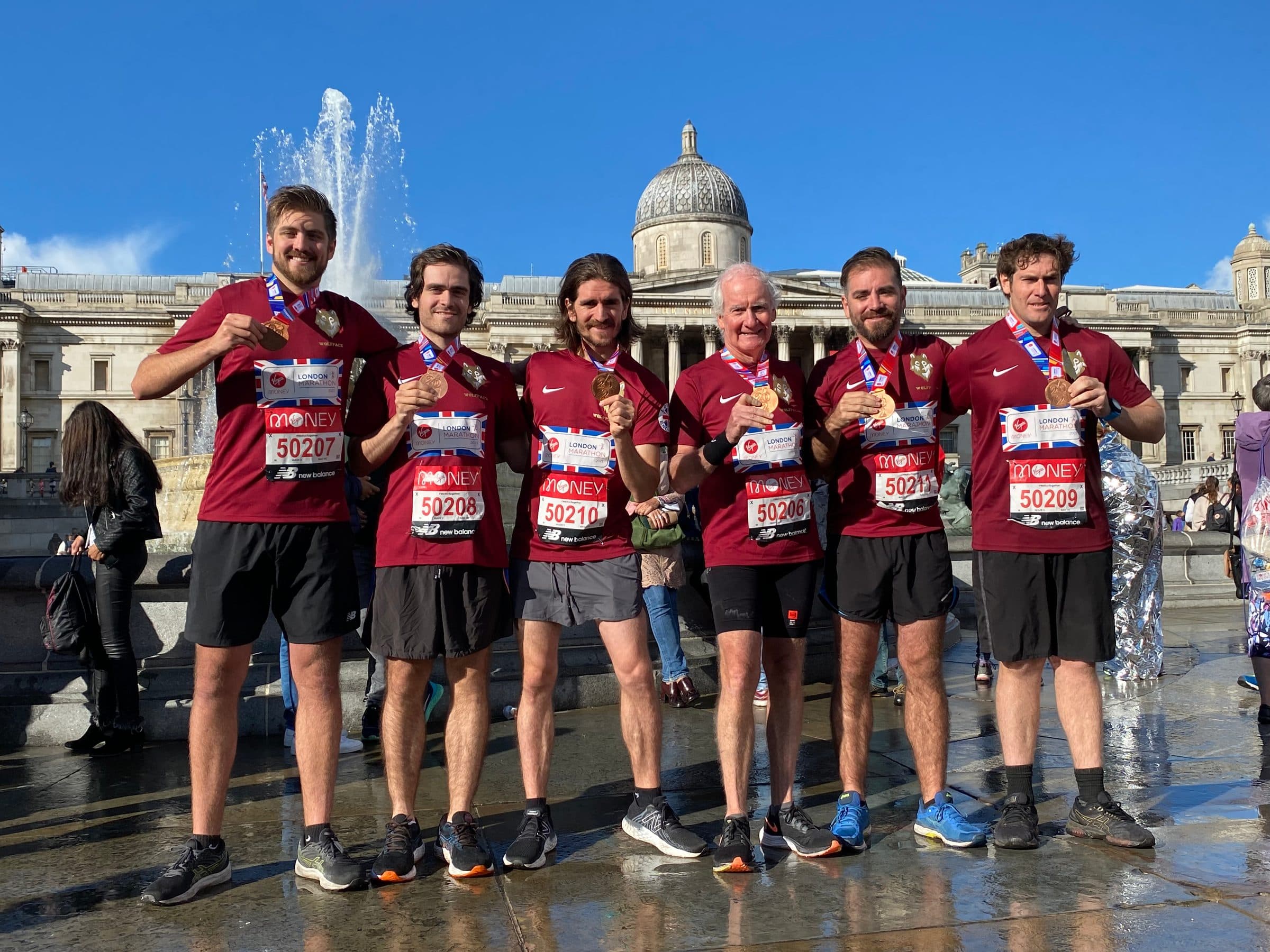 Los seis corredores con camisetas granate del Team Abbott y sus medallas de Londres en Trafalgar Square.